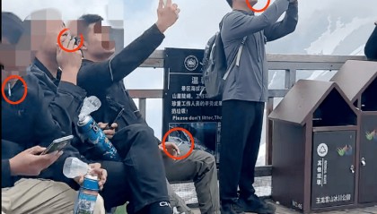 玉龙雪山4500米观景平台上几名男游客手持氧气瓶，一边吸氧一边抽烟，景区回应：将加强劝导